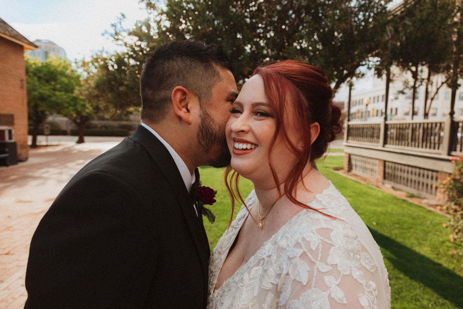 A tender wedding moment shared between a couple outdoors with natural lighting.