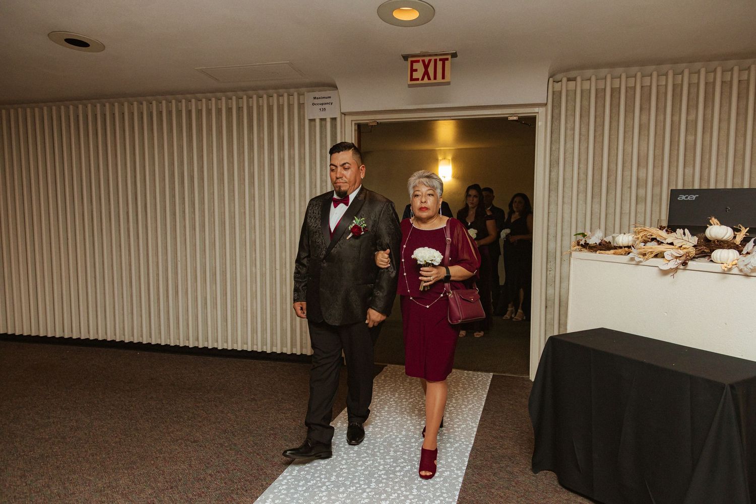 Wedding guests walk through a venue hallway during the reception.
