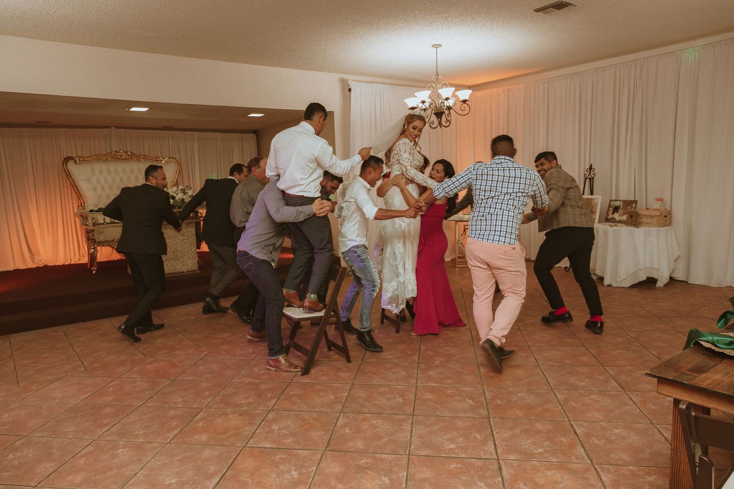Wedding guests dancing energetically on the dance floor at a reception.