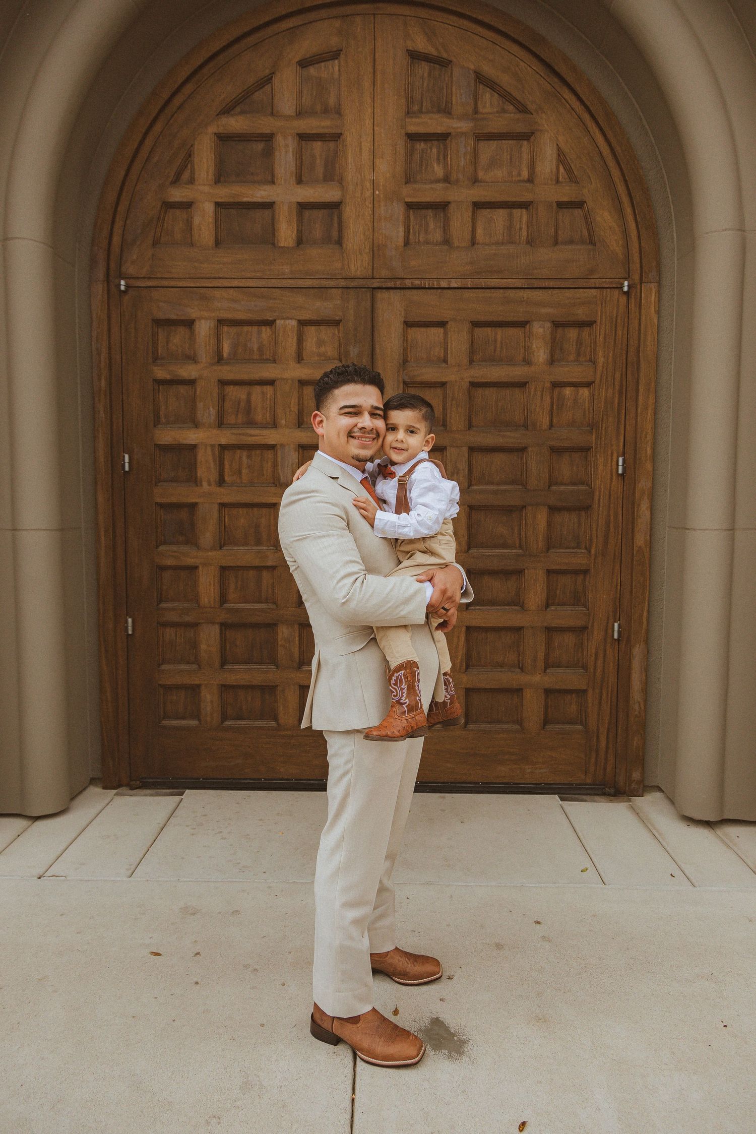 A tender moment captured against a wooden church door.