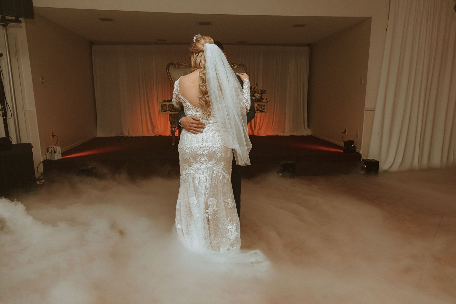 Couple shares an intimate wedding dance moment surrounded by atmospheric fog effects.