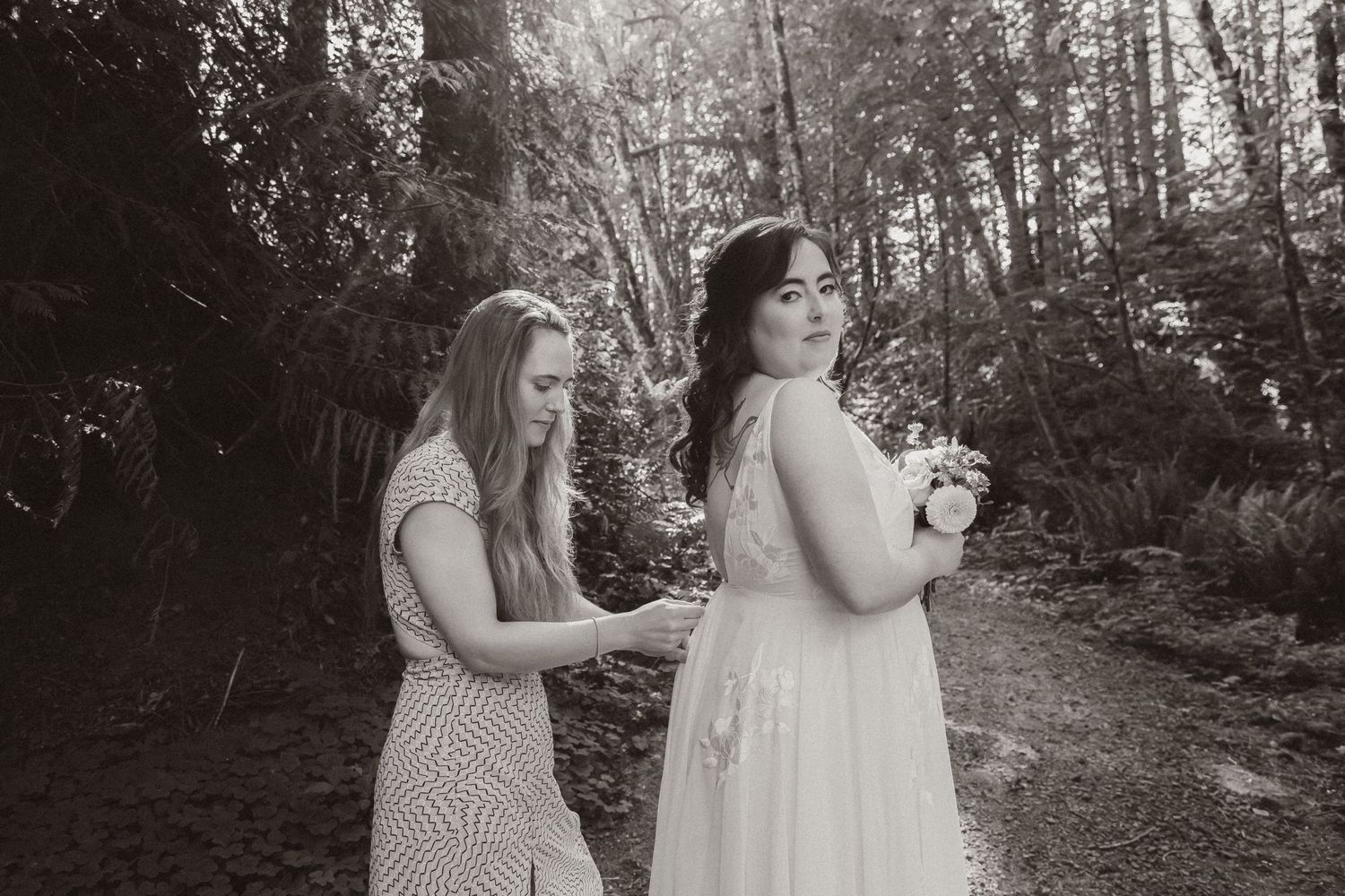Two people enjoying a lighthearted moment on a wooded forest path.