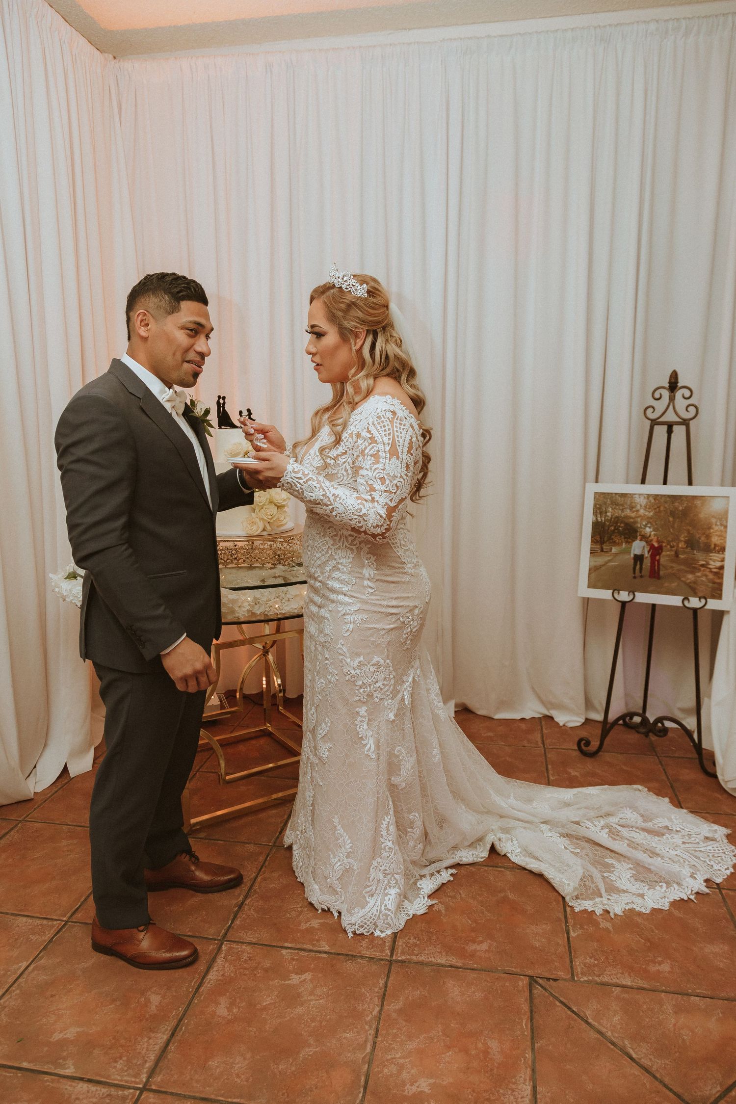 Wedding couple sharing laughter during their cake-feeding moment at the reception.