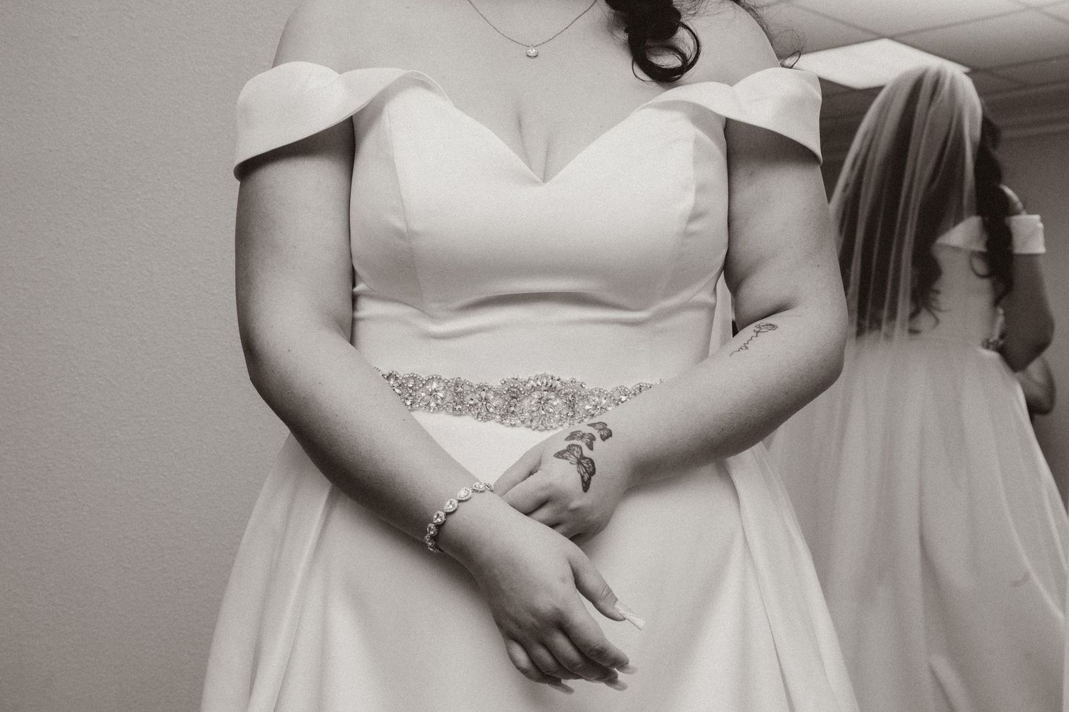 Black and white photo of a wedding dress bodice with crystal embellished waist detail.