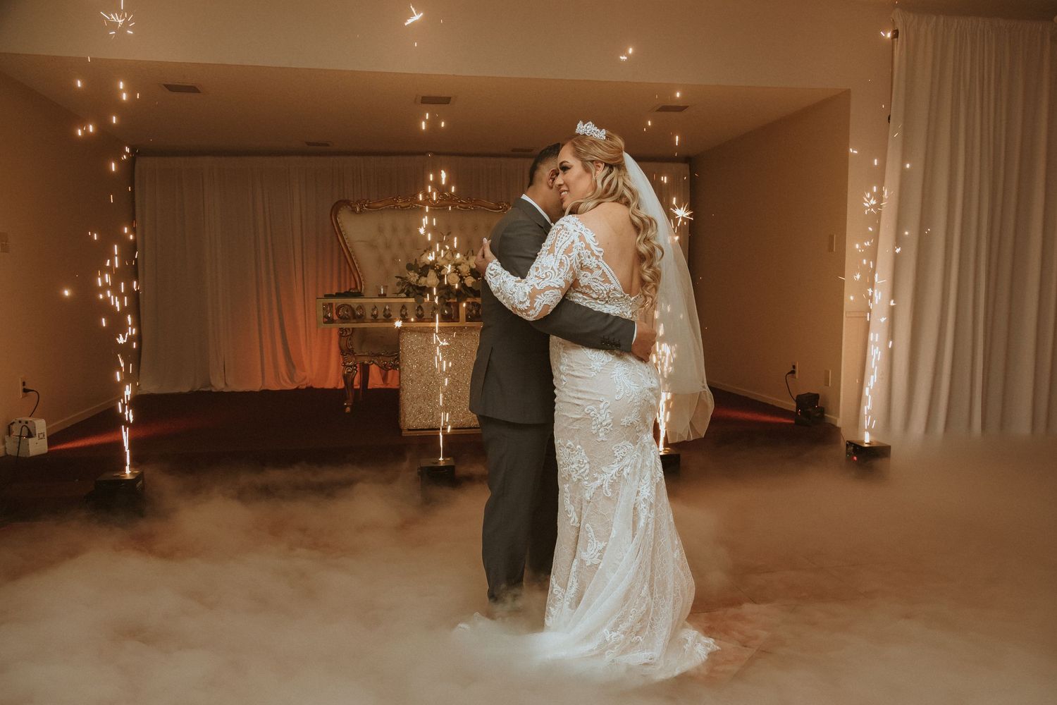 Romantic dance moment captured with sparkler fountains and fog effects creating a dreamy wedding atmosphere.