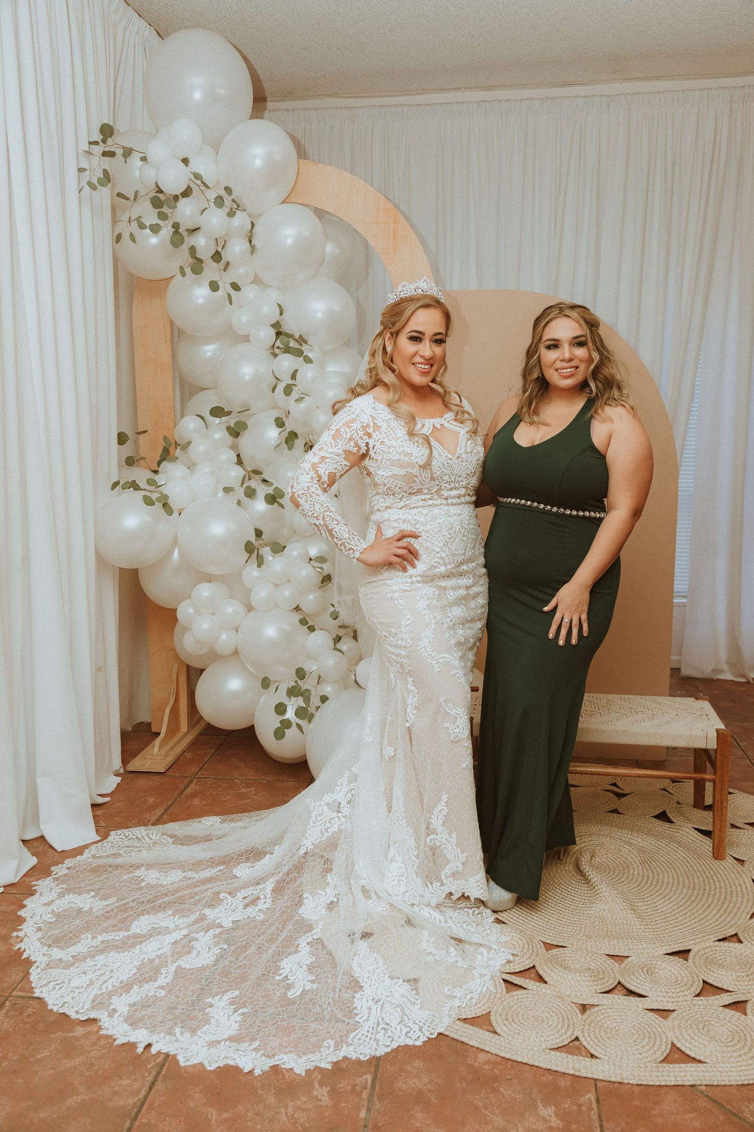 Wedding photo showing detailed lace train and formal wear against decorative balloon backdrop.