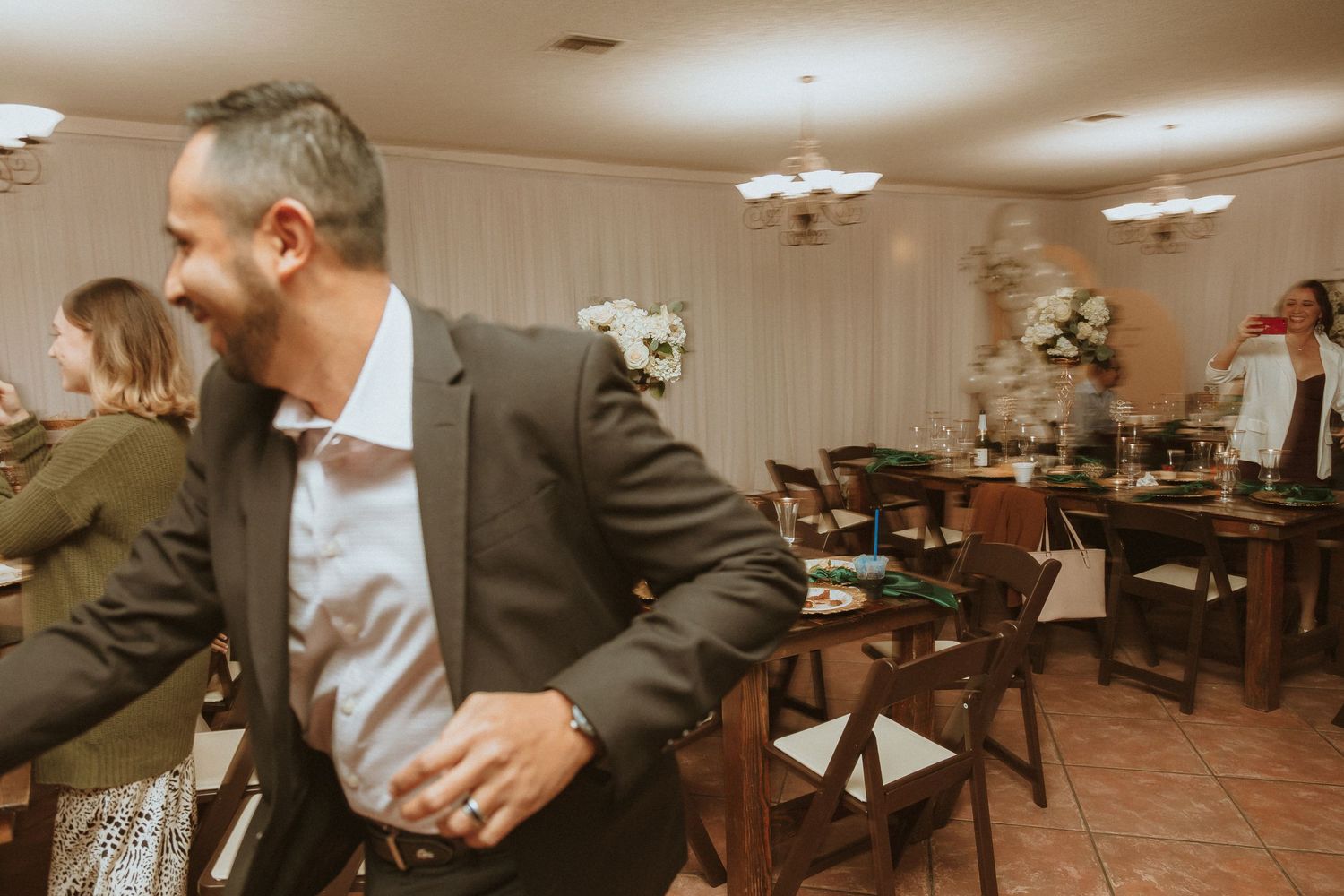 Guests dance in motion during a festive indoor wedding celebration.