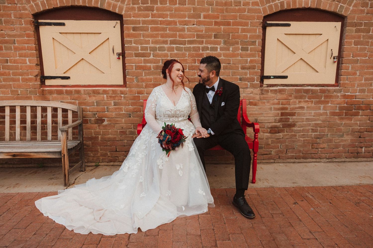 A romantic wedding photo featuring vintage architecture and rustic wooden accents.