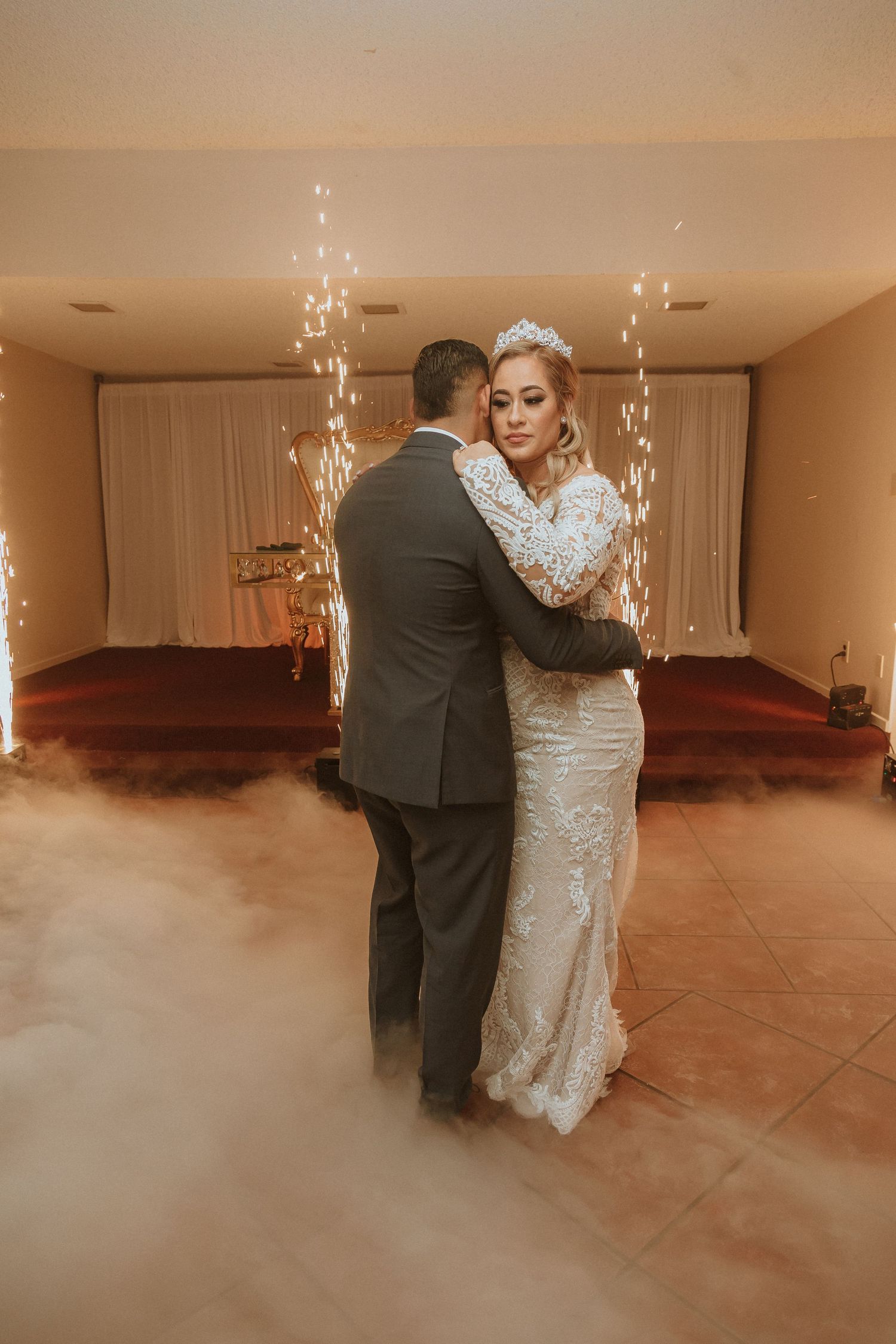A romantic first dance moment with sparkler effects and low-lying fog creating ambiance.