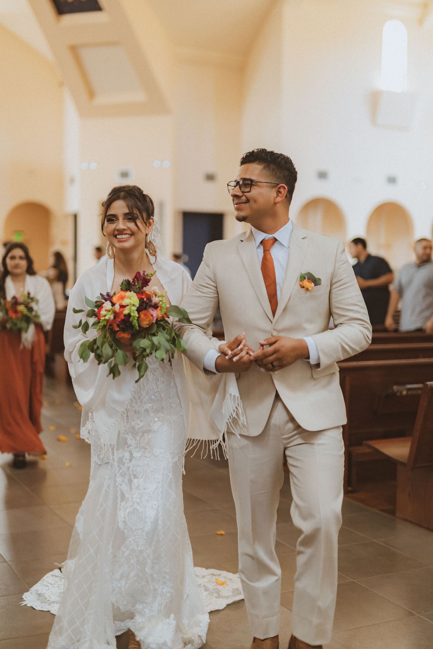 A couple walks down the church aisle together during their wedding ceremony.