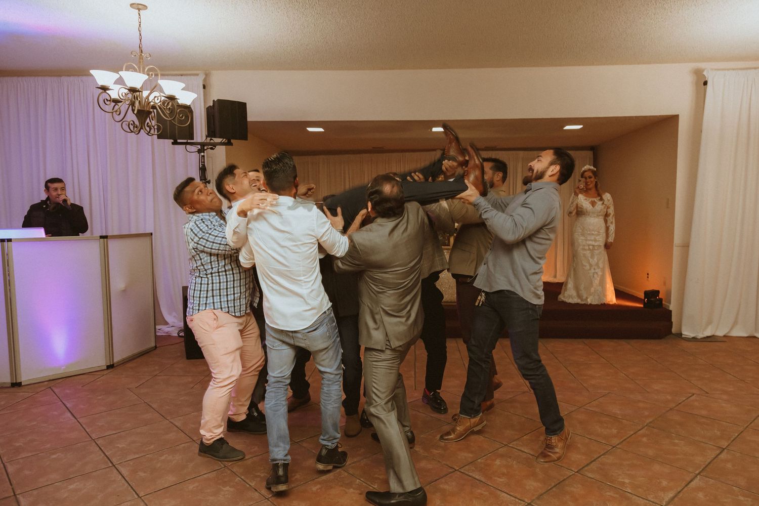 A group of people work together to lift someone during a celebratory moment.