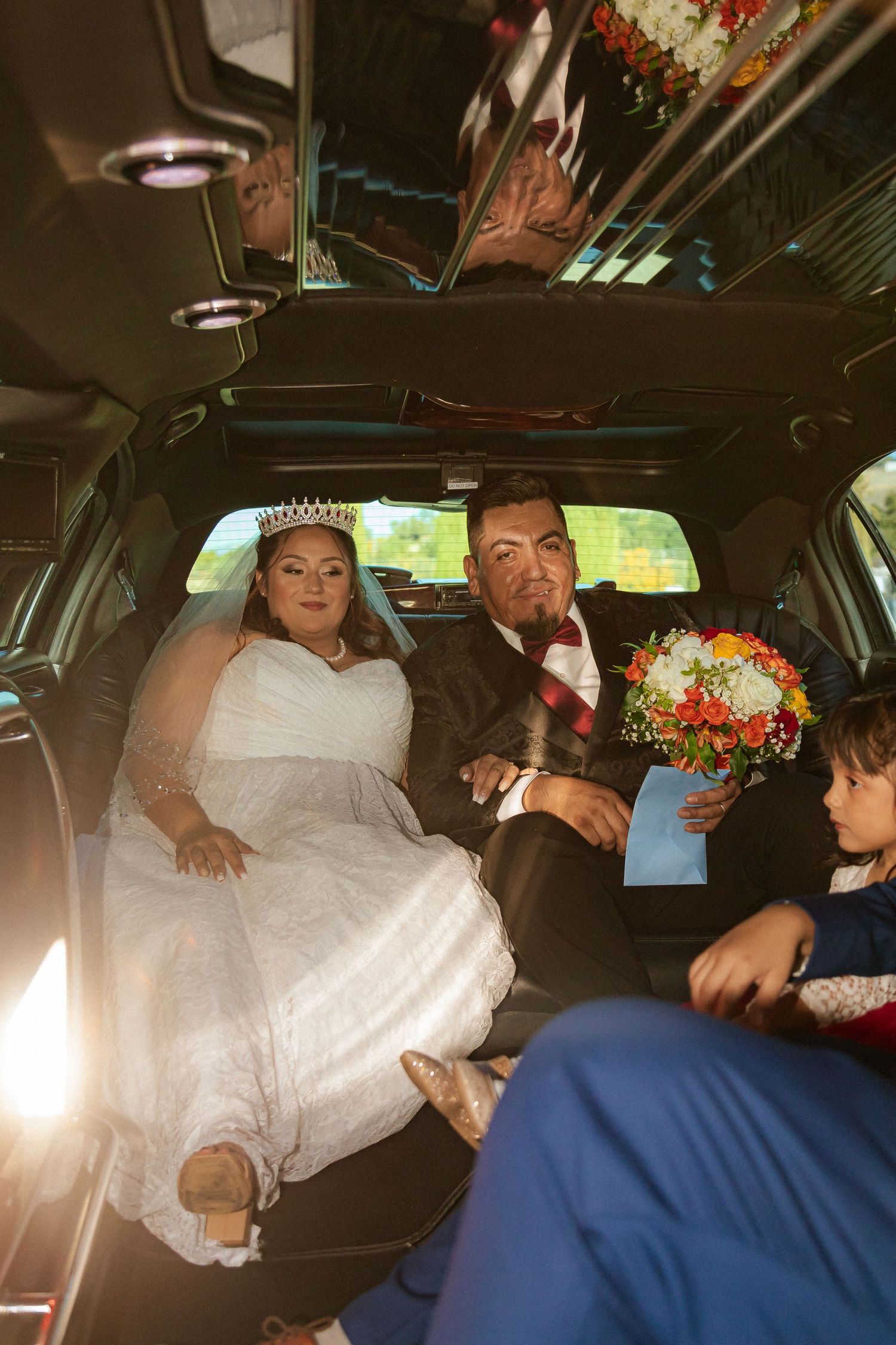 Wedding party captures a casual moment inside a luxury limousine during celebrations.