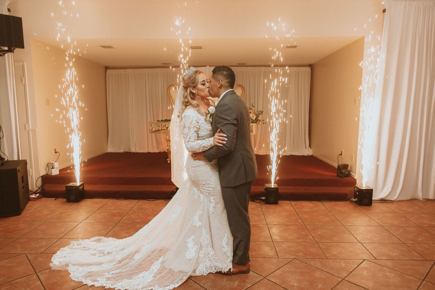 A tender wedding moment captured in warm tones with sparkler effects and elegant decor.