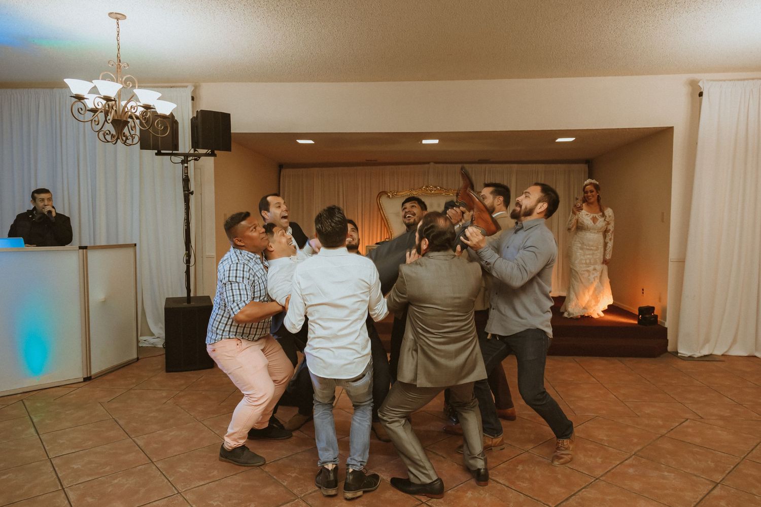 Men dancing in a circle during a lively wedding reception celebration.