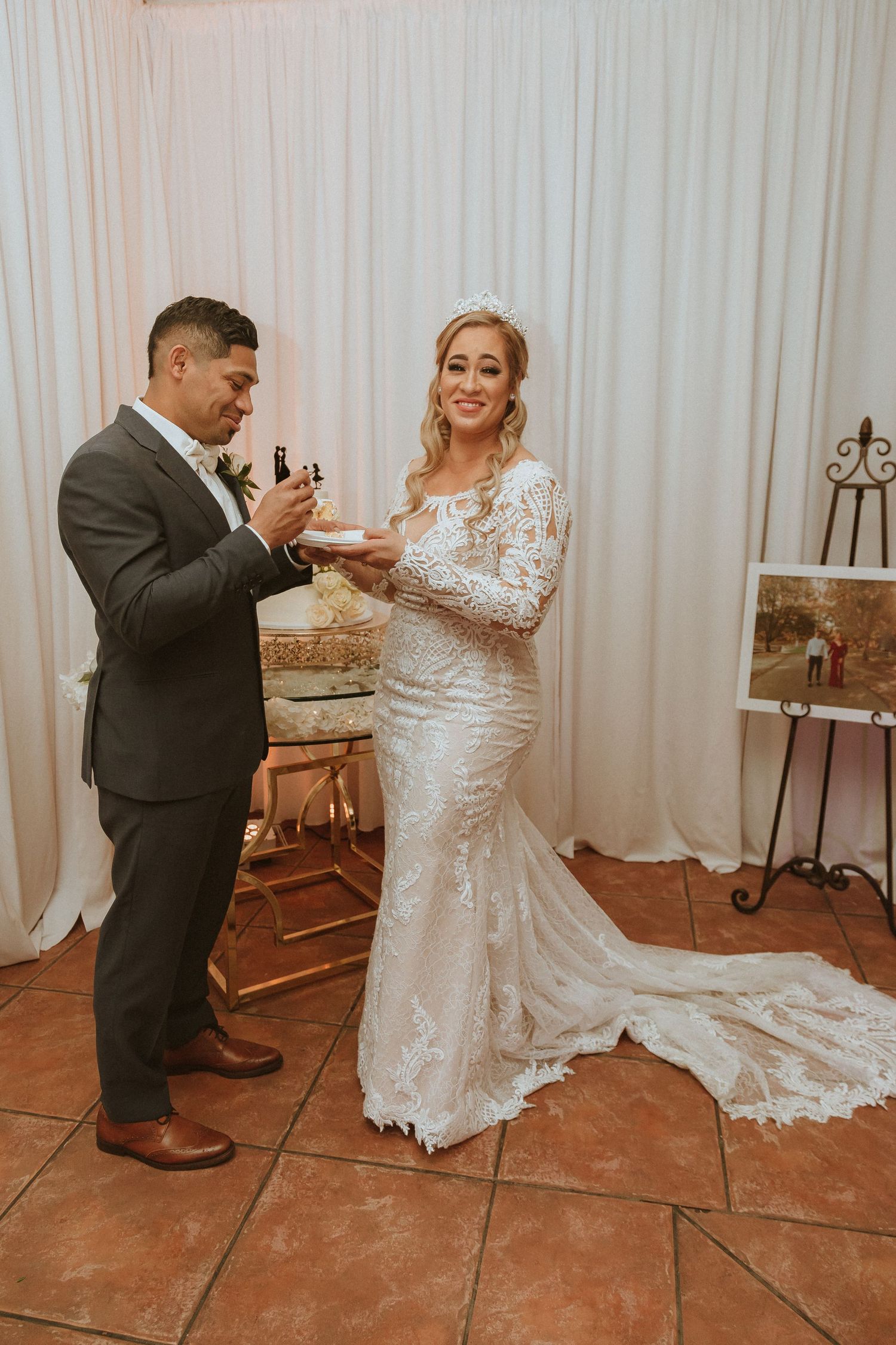 Couple participating in the cake-feeding tradition at their wedding reception.