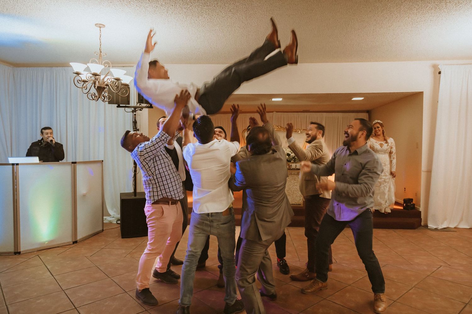 Party guests throw someone into the air during an energetic celebration.