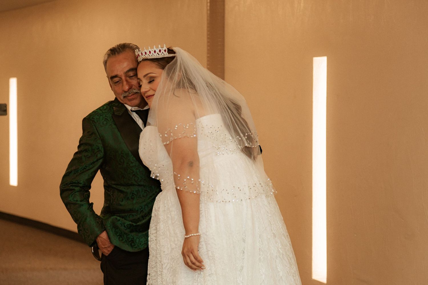 A tender moment captured during a wedding celebration in a warmly lit venue.