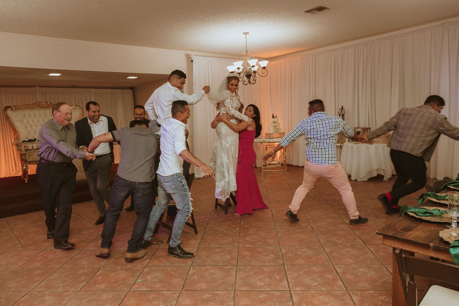 Wedding guests engaged in enthusiastic group dancing during the reception celebration.