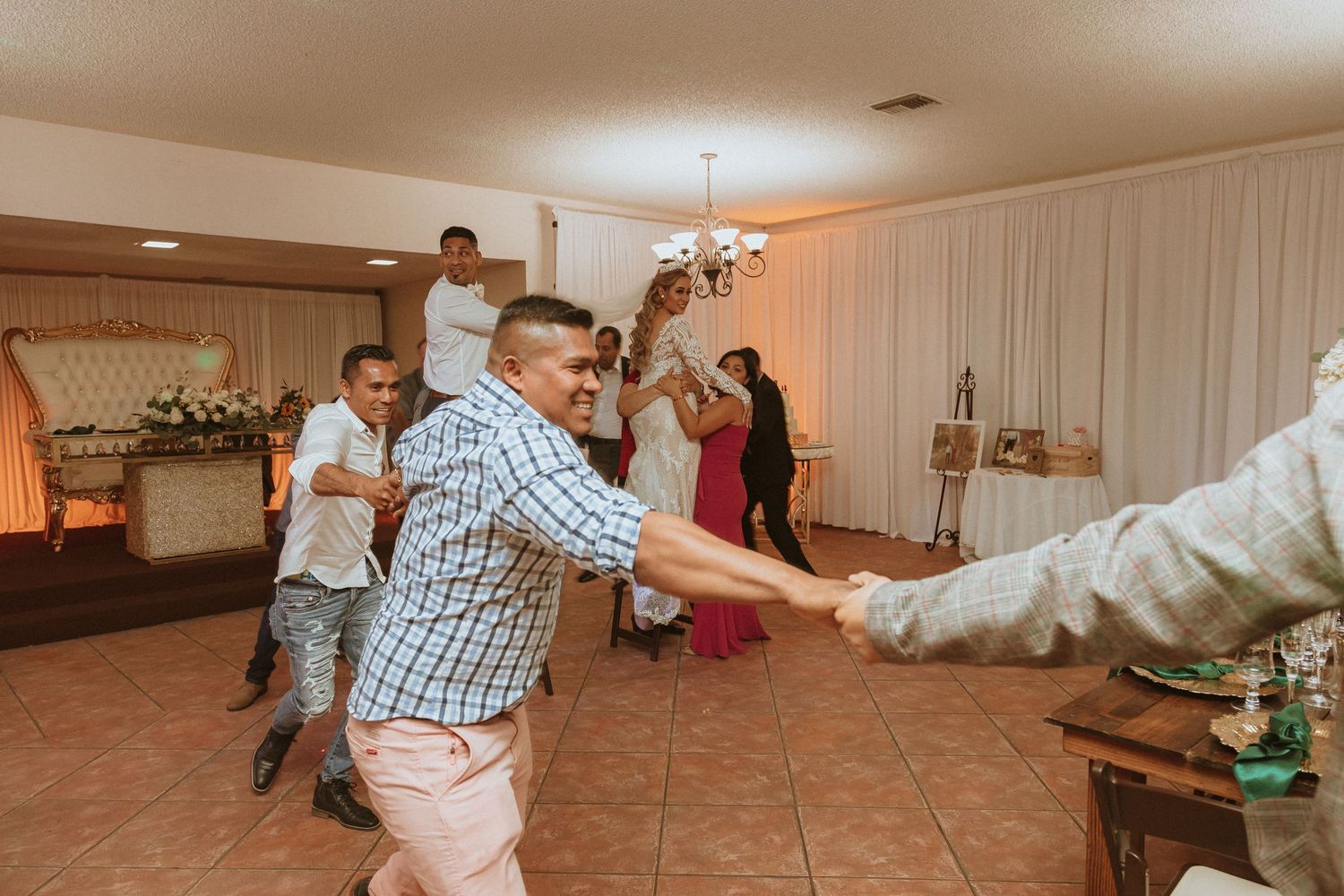 Dancers forming a line while performing choreographed moves at an indoor celebration.