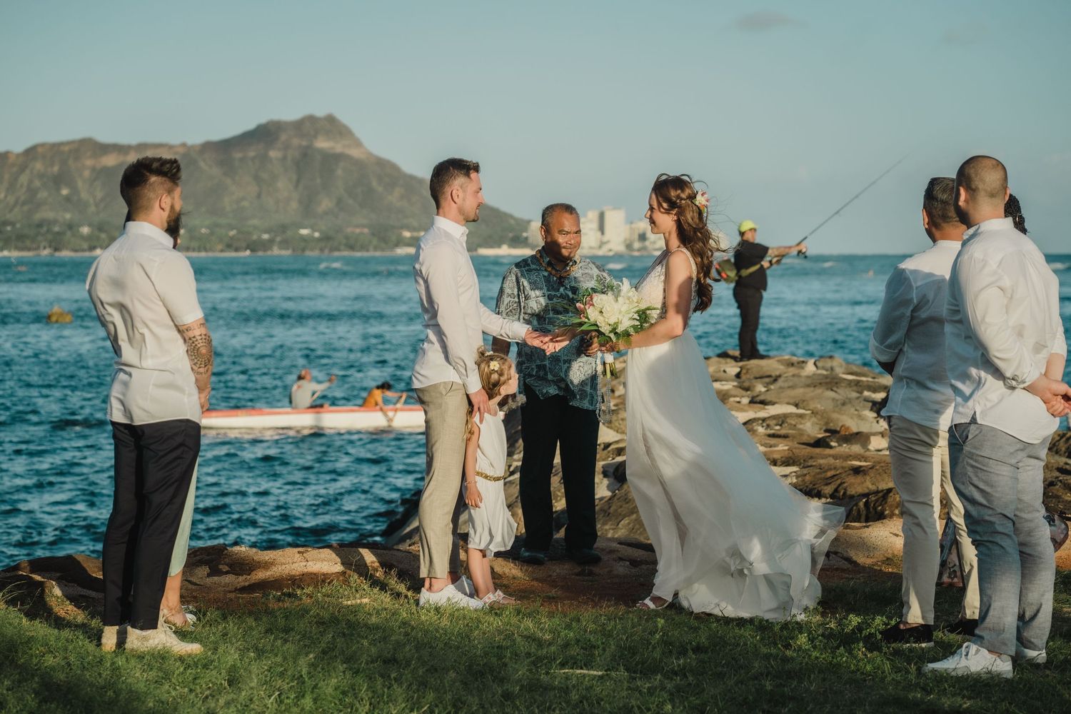 Wedding ceremony on a scenic Hawaiian beach with Diamond Head in the background, surrounded by palm trees and ocean views.