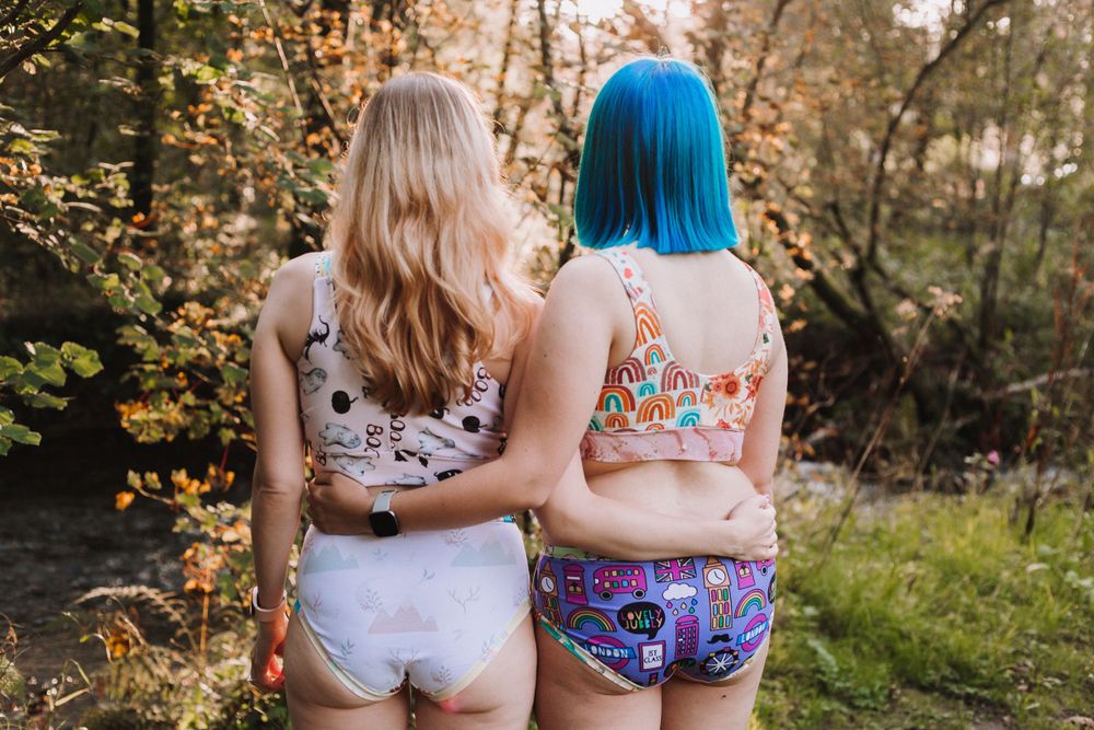 Back view of people wearing patterned swimsuits standing together on a nature trail.