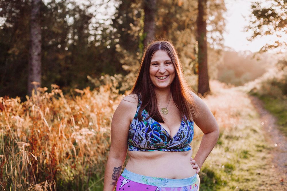 People in bright swimwear photographed against a sunlit forest backdrop.