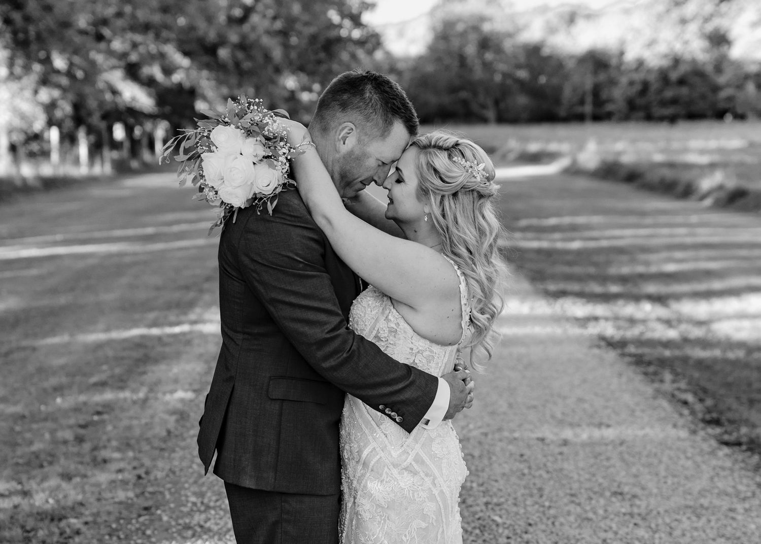 Black and white wedding photos showing romantic moments outdoors.