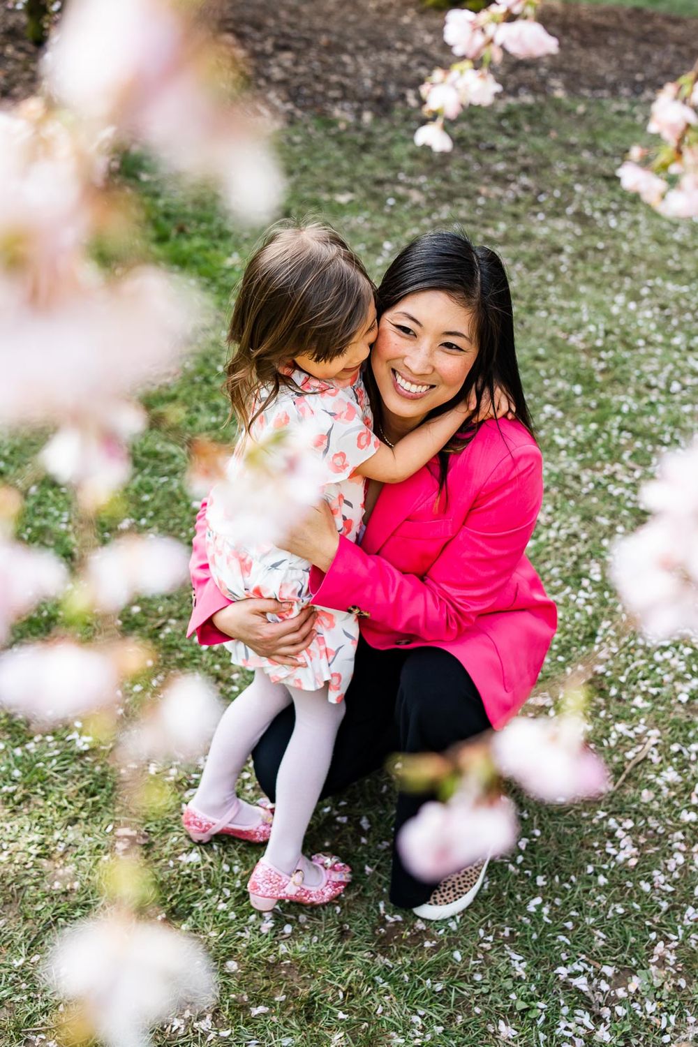 Cherry blossoms frame mother hugging daughter at the Seattle Arboretum