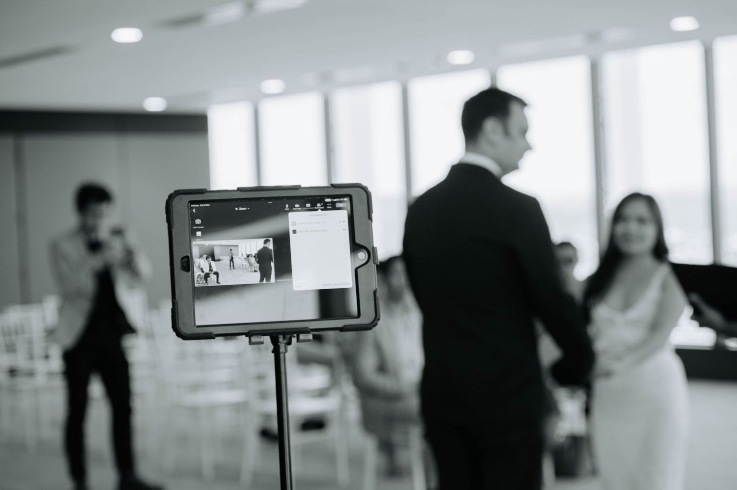Black and white photo of a wedding videography setup with LCD screen display.