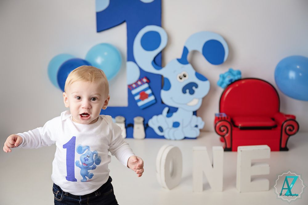 First birthday setup with blue decor, white letters, and red chair for Blues Clues theme celebration.