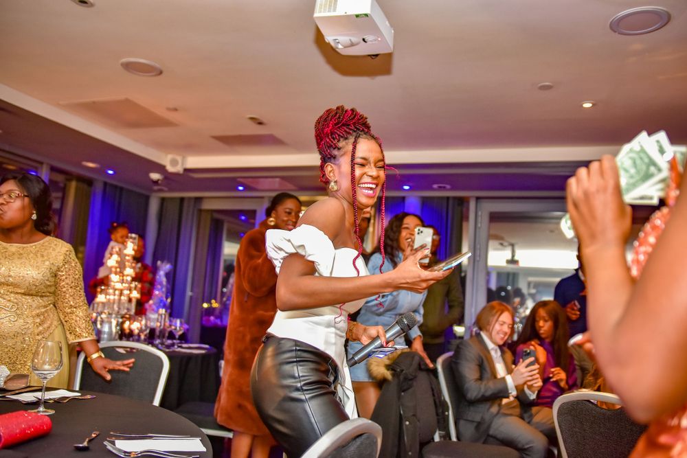Women celebrating at a party with money being thrown in the air at an indoor event.
