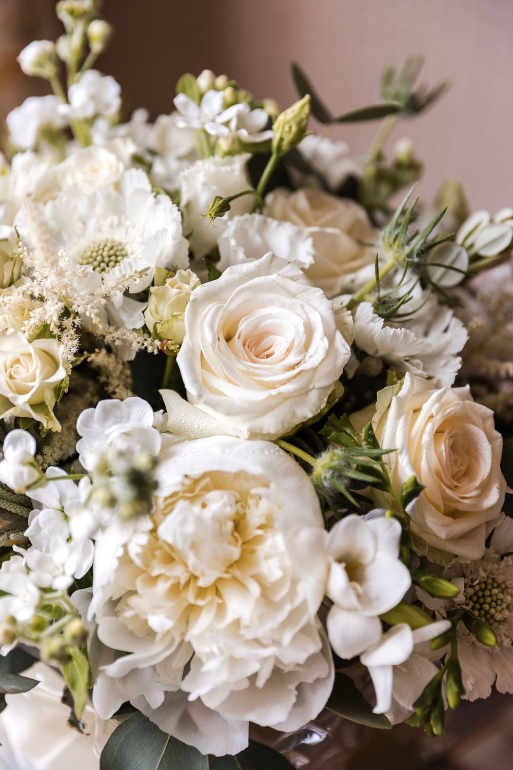 Elegant white and cream floral arrangement with roses and mixed flowers.