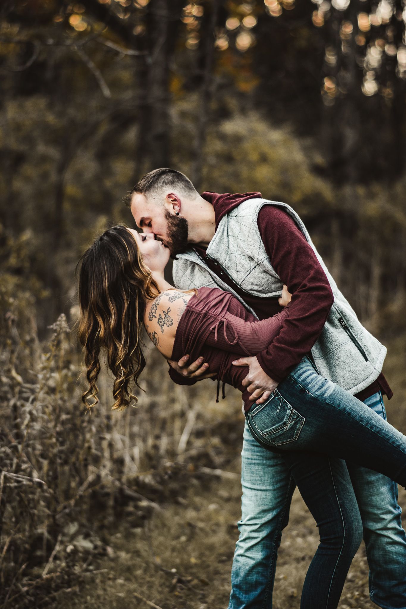 A romantic couple sharing a passionate dip kiss in an autumn setting with warm lighting.
