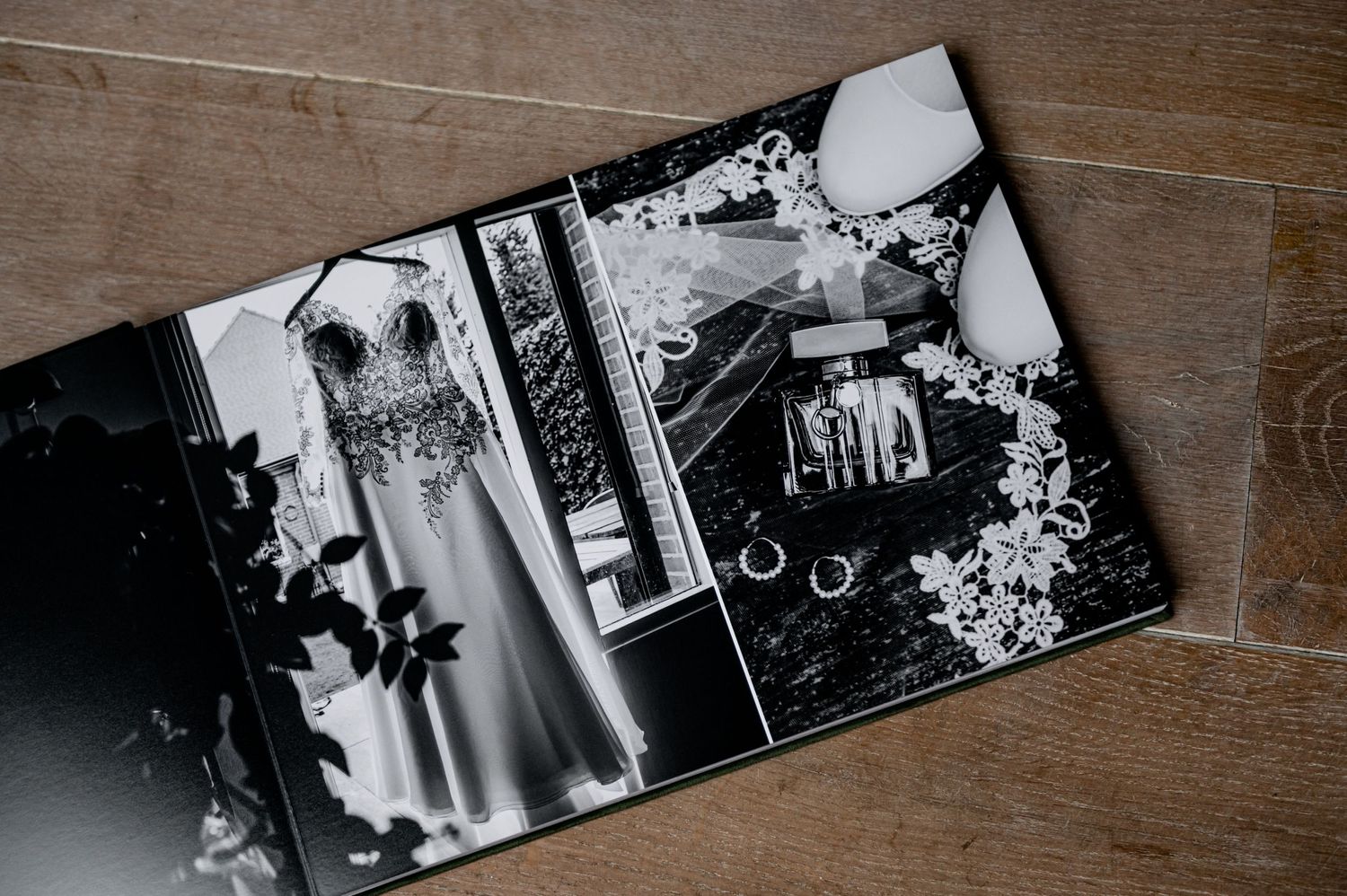 Black and white photo album pages displayed on a rustic wooden surface.