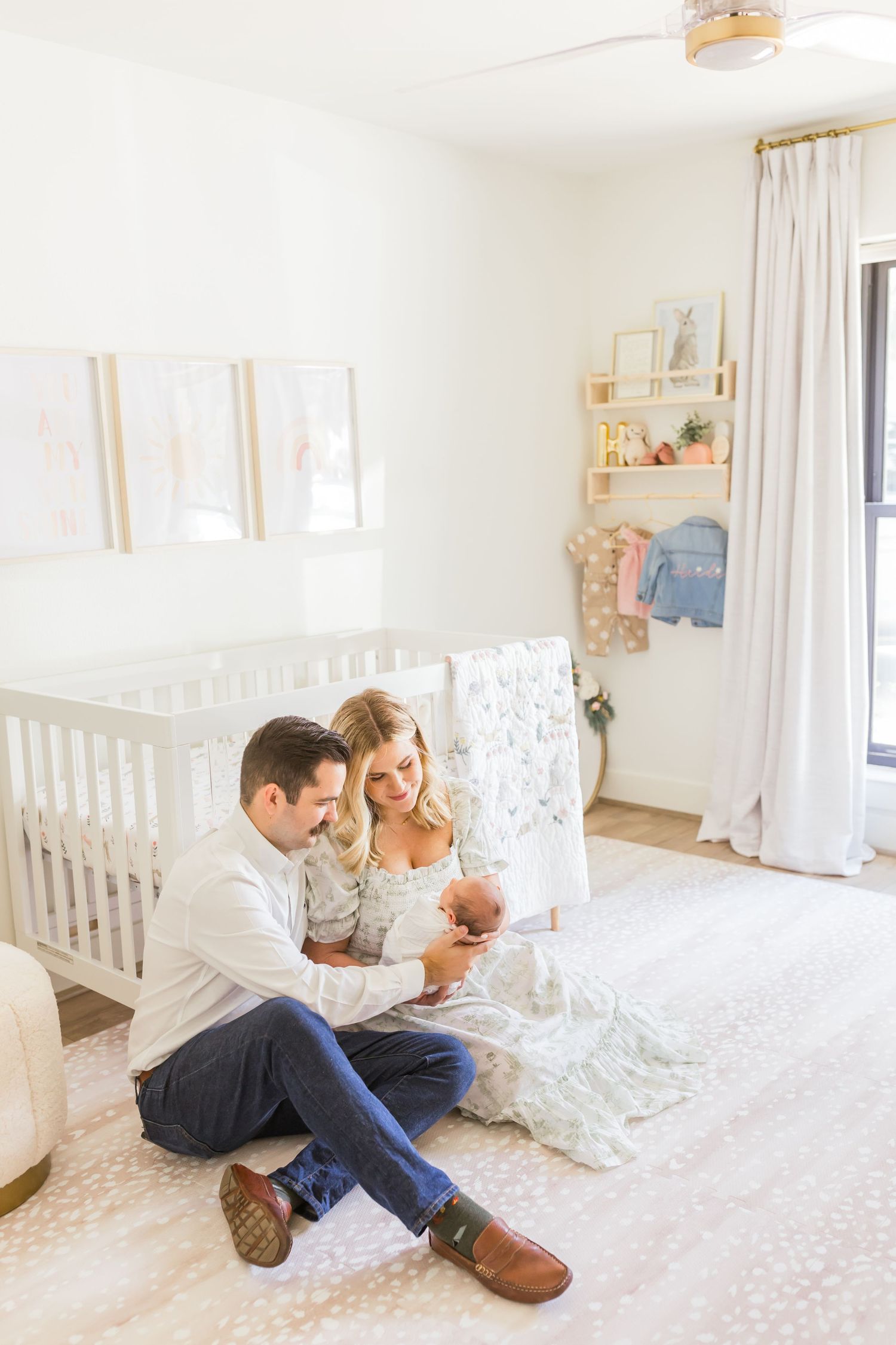 A peaceful nursery scene with white furniture and soft pink carpeting.
