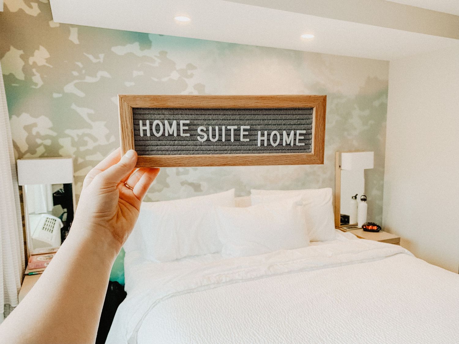 Bright hotel room interior with decorative wall art and bedding.