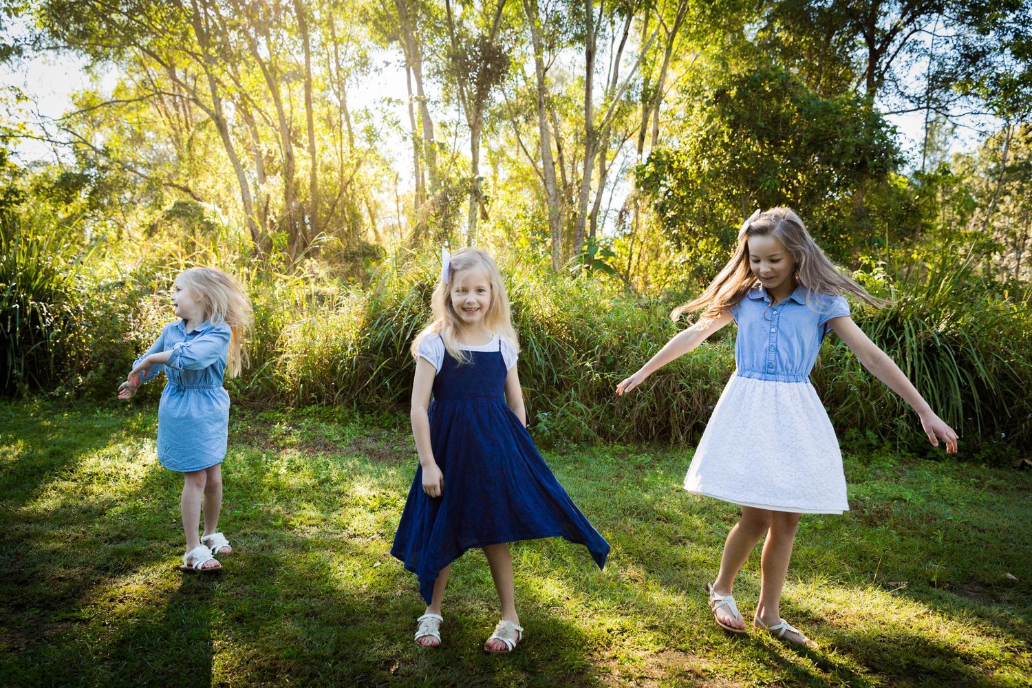 girls twirling on the grass outdoor portrait