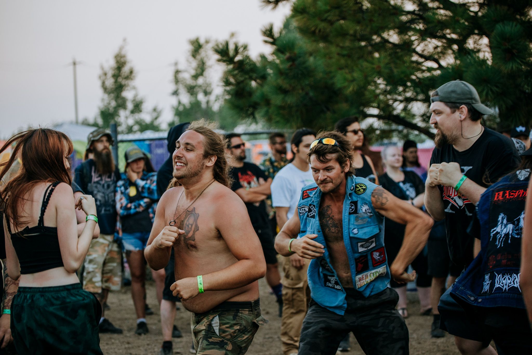 Energetic crowd dancing at an outdoor music festival with people in casual summer attire.