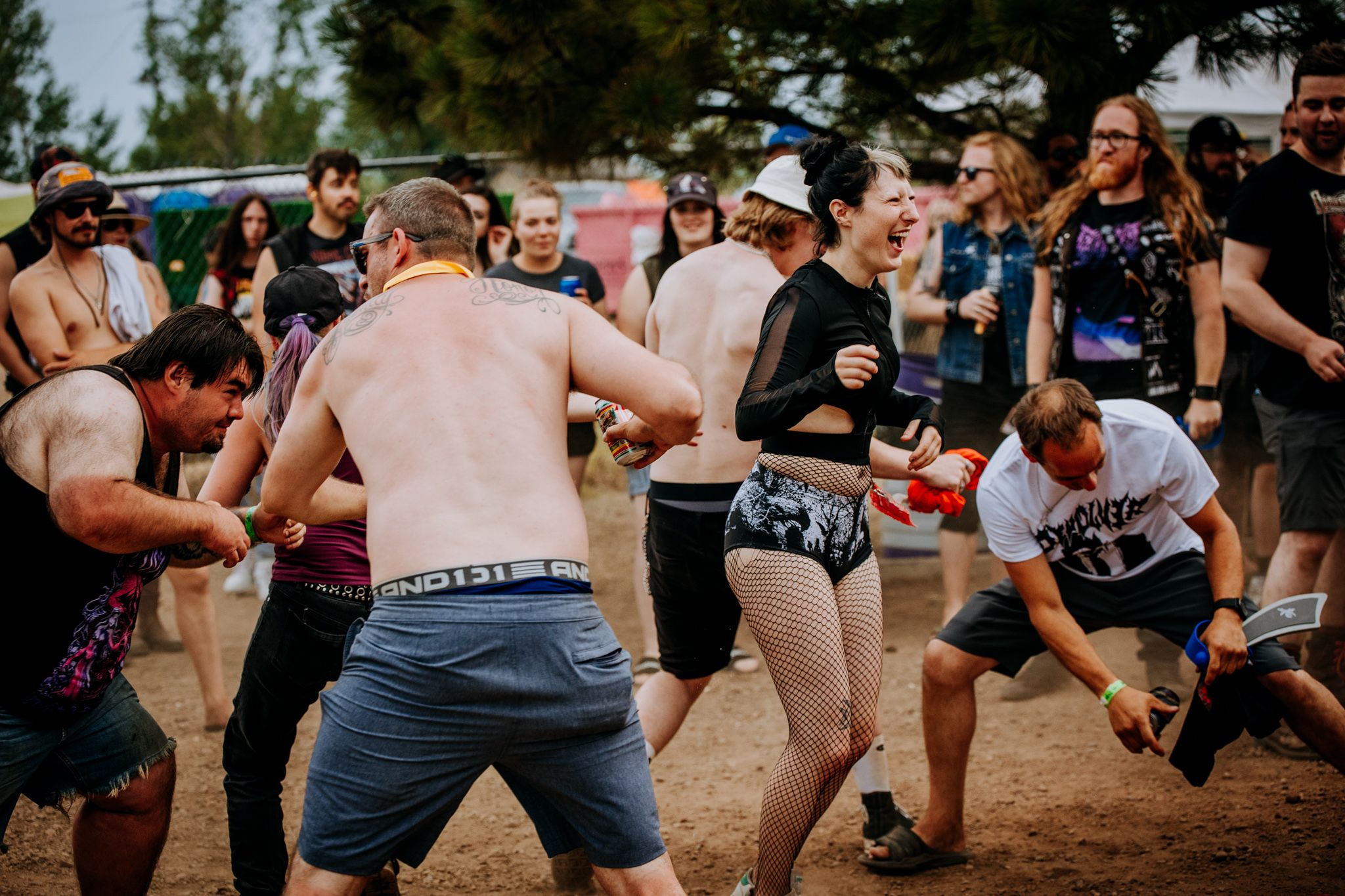Energetic crowd moving and dancing during outdoor music festival performance.