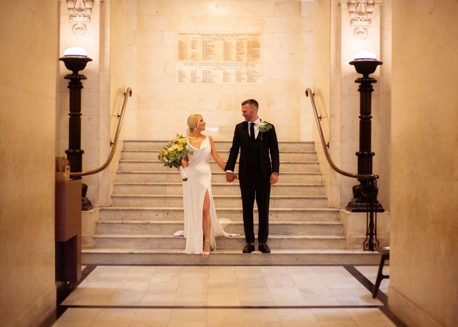 bride smiling at groom on the internal steps of Old Marylebone Town Hall, London by Dominique Lauren photography