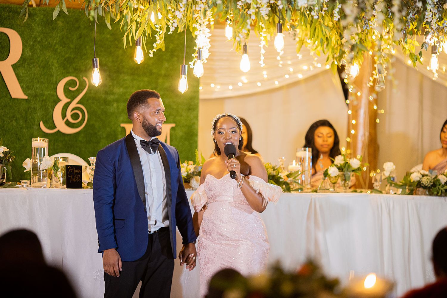 Beautifully decorated wedding reception with floral ceiling arrangements and ambient lighting.