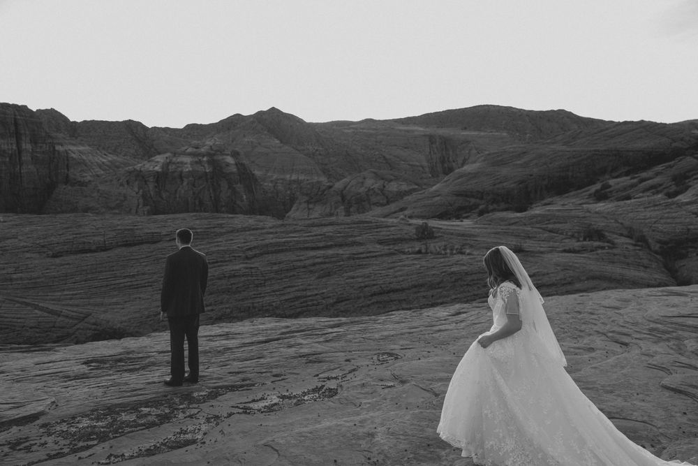 Dramatic wedding photography in a desert landscape with red rock formations.