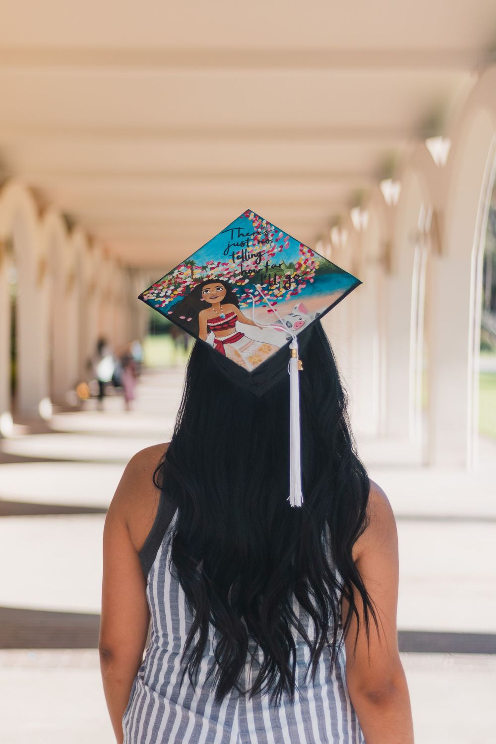 Outdoor graduation portrait of a college senior in decorated cap and gown in Fresno, California