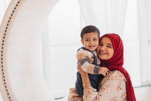 A sweet moment between two people framed by a circular white mirror.