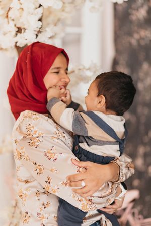 A tender moment between parent and child surrounded by white floral decorations.