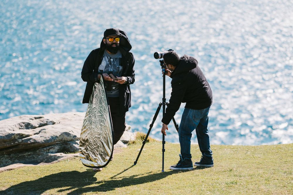Saieash and Jana from Film Drop setting up a camera and reflector for a pre wedding shoot at Watsons Bay in Sydney