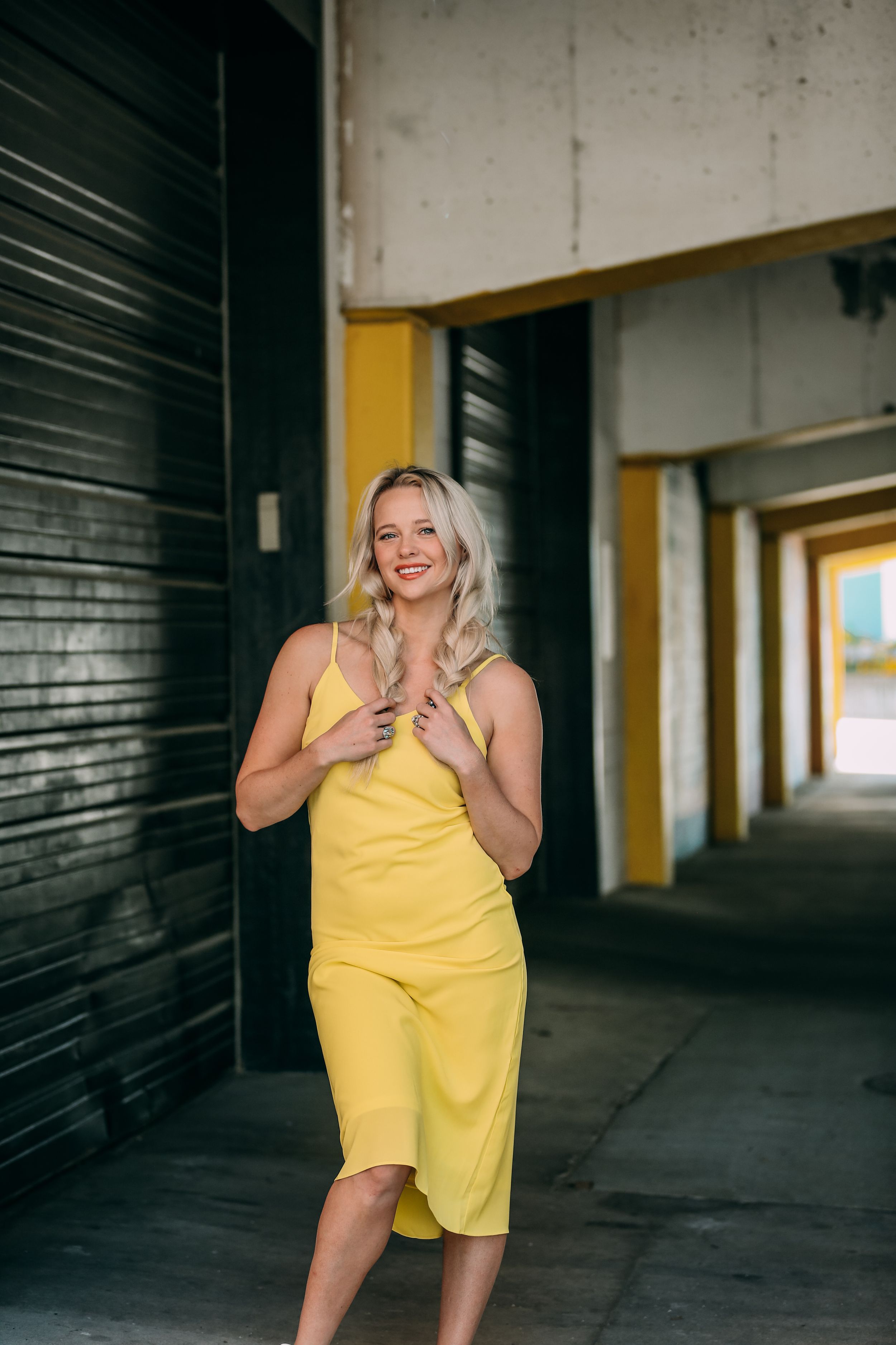girl in yellow dress by black garage