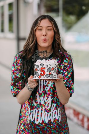 girl blowing out candle on cake