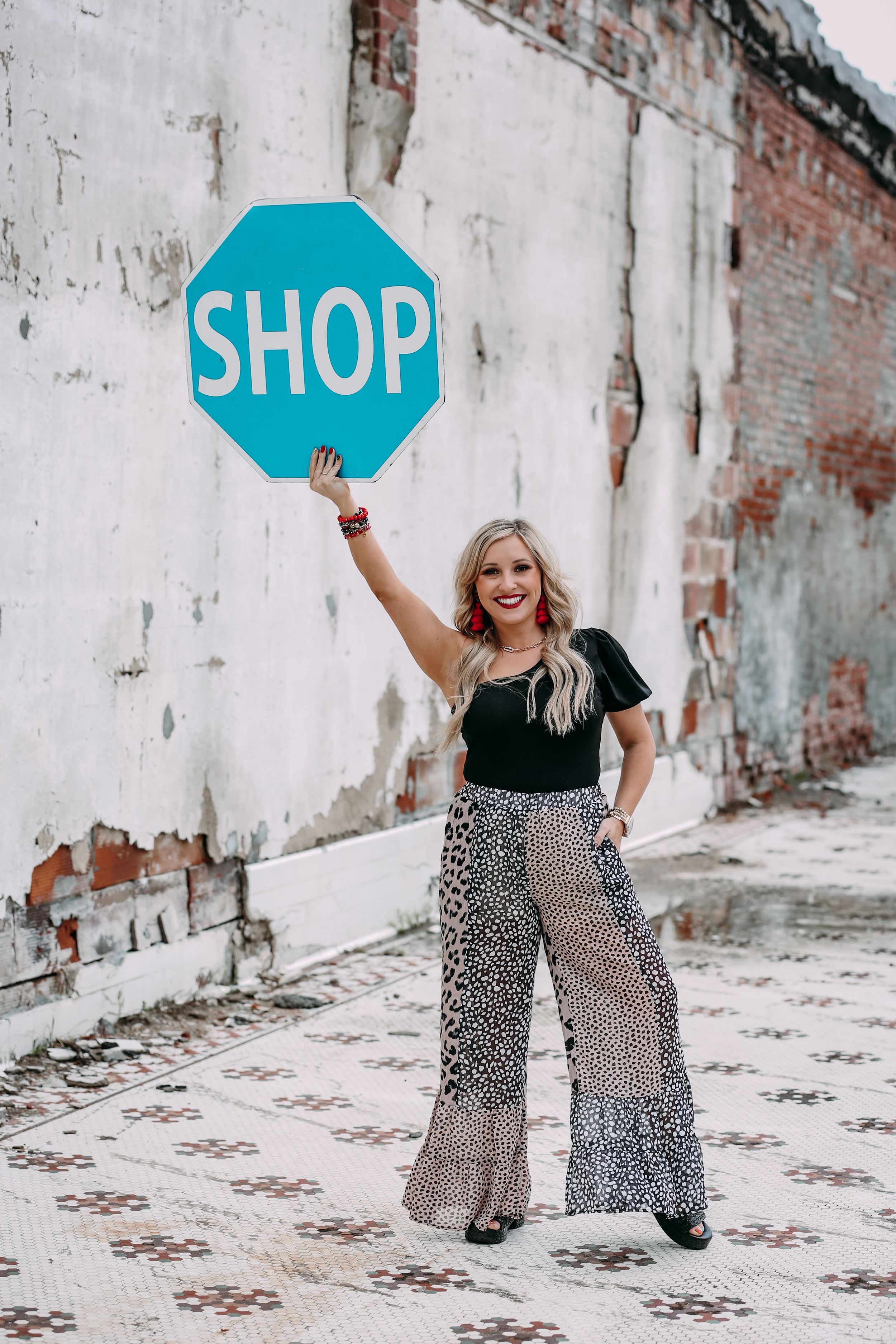 boutique owner holding a shop sign
