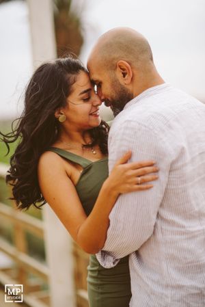 A romantic couple shares an intimate moment outdoors while embracing each other tenderly.